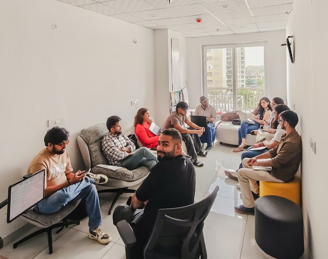 A circle of IXC Commons members deep in conversation at a Coffee with Claude session.