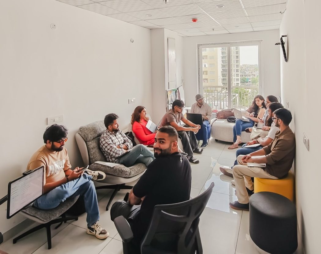 A circle of IXC Commons members deep in conversation at a Coffee with Claude session.